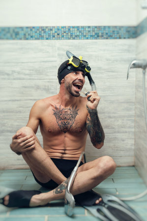 a man wearing a scuba mask in the shower is doused with water