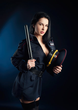 Portrait of a woman in a Russian police uniform with a baton English translation policeの写真素材