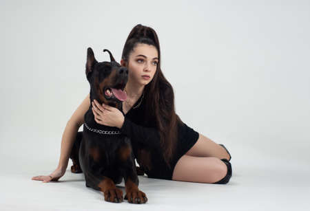 beautiful woman with a doberman on a white backgroundの写真素材