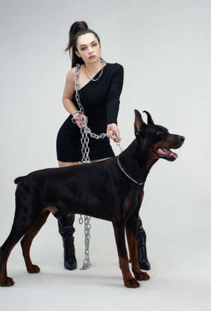 beautiful woman with a doberman on a white backgroundの写真素材