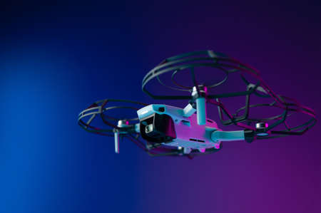 The smallest drone. unmanned aerial vehicle with blade protection and camera in flight in neon light . Russiaのeditorial素材