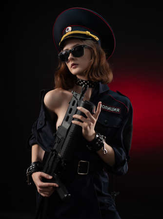 naked girl in a police uniform with a gun . English translation of the policeの写真素材