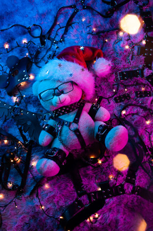 a bear in a Santa Claus hat is a Christmas gift for BDSM games from a sex shop in neon light for the new yearの写真素材