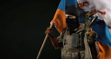 a male soldier in a military uniform with a balaclava and hands covered in blood holds a bloody flag...