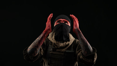 photo of a man in a military uniform and balaclava with a bloody face and hands up to the elbow in...