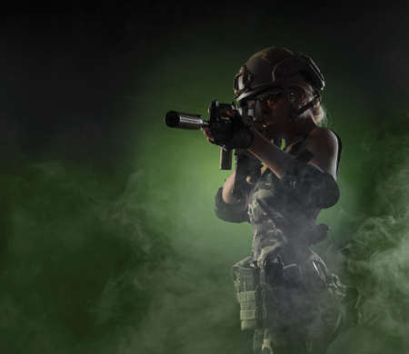 a girl soldier armed with an automatic rifle takes aimの写真素材