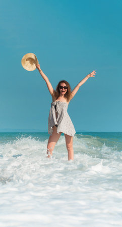 a beautiful girl in a swimsuit in summer on the seashore happily having fun on the water with...