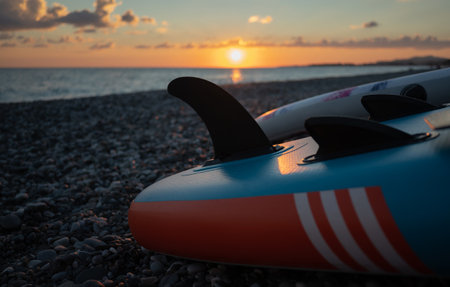 sup board fin close-up at sunset by the seaの写真素材