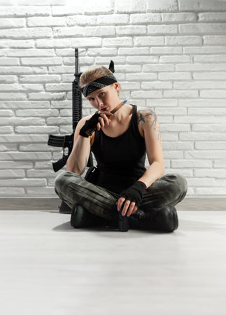 beautiful girl soldier with a walkie-talkie and an airsoft rifle on a white background copy paste