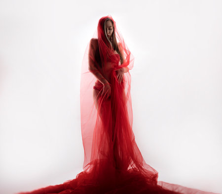 sexy girl with red transparent fabric on a white background copy pasteの写真素材