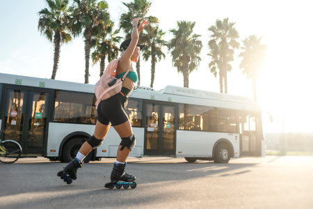 A sporty girl on roller skates against the background of the city in the sunset light on a summer...