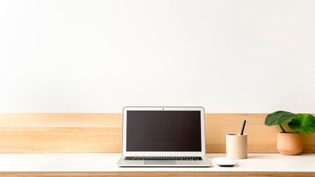 Laptop and plant pot on wooden desk with white wall background with copy space. Business concept. Home office concept.の素材