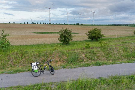 bicycle in the field with wind turbines in the background on a cloudy dayの写真素材