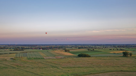 Hot air balloon over the countryside in the evening. View from above.の写真素材