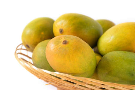 indian mangos in a basket on a white background in close up viewの写真素材