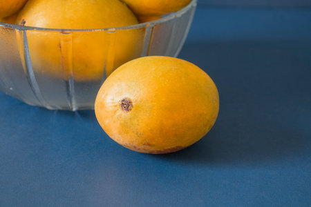 indian mangoes in basket blue dark background close up view