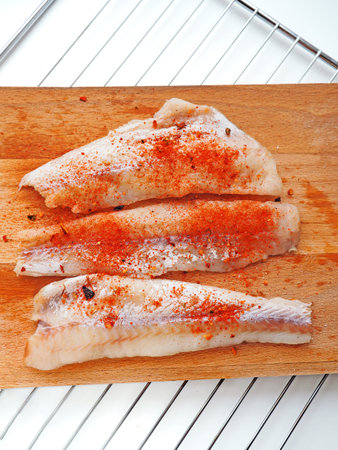 Fish fillet salted and pappered for cooking or grill on wooden background