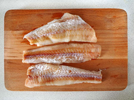 Fish fillet on wooden cutting board Food making backgroundの写真素材