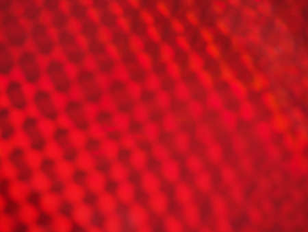 Holographic colorful red lights festive background. Abstract geometric pattern backdrop. Design for your ad, poster, bannerの写真素材