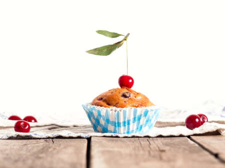 Freshly baked cherry muffins with fresh berries on a rustic wooden tableの写真素材