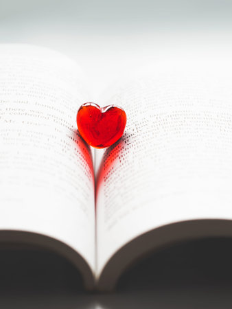 Red transparent glass heart lay in a book. Valentine's day concept. Beautiful romantic backdrop.