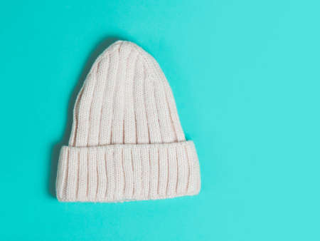 Warm woolen knitted hat turquoise colored background. Festive christmas wear.の写真素材