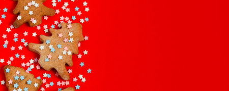 Gingerbread christmas trees cookie decorated with mastic star icing on bright red background....