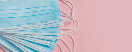 Medical protective mask on a pastel pink background. Individual, disposable surgical face mask....