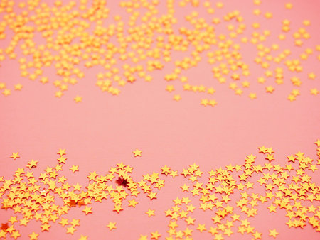 Golden stars glitter on pink background. Festive holiday bright backdrop