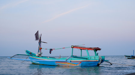 Fishing boats on the beach when the sun begins to set with a beautiful backdrop of sea and sand.の写真素材