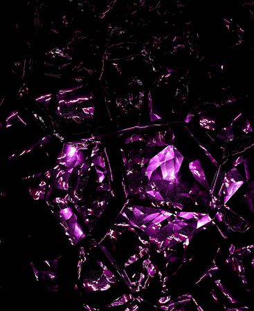 Broken, shattered purple glass effect on black background.の写真素材