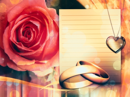 Golden wedding rings and beautiful red rose background.の写真素材
