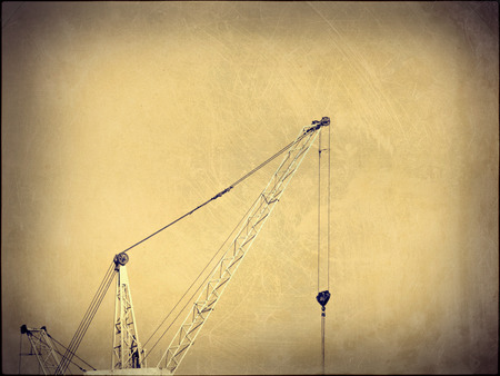 Crane and building construction site against blue sky.