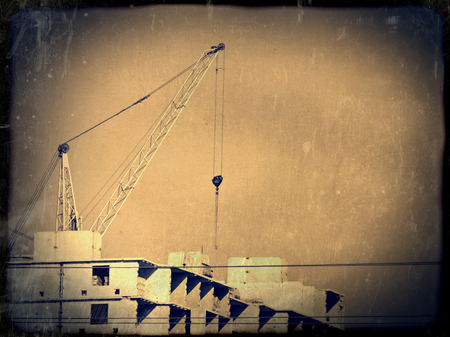 Crane and building construction site against blue sky.の写真素材