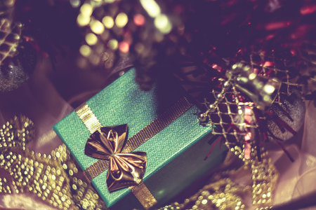 Decorative red Christmas tree and green gift box with gold bow.