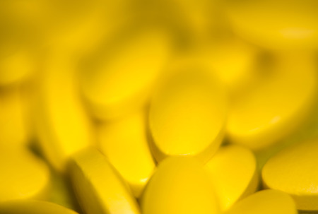Macro of yellow pills, abstract defocused background.の写真素材