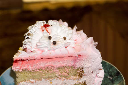 Macro of tasty cake with white, pink cream and chocolate decorations.の写真素材
