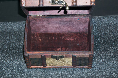 Close up of a decorative wooden box chest on dark background.
