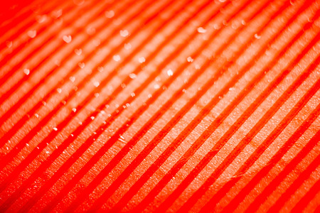 Abstract red background with stripes and water drops.の写真素材