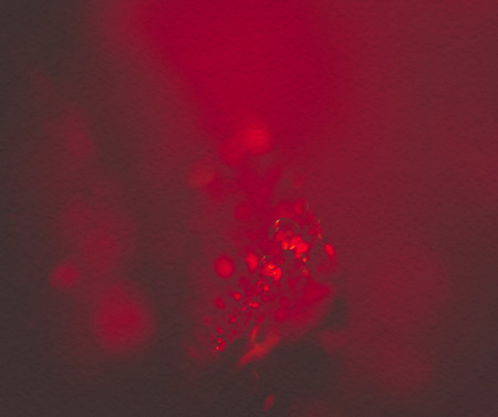 Extremely close up of red rose in water drops, shallow focus, vintage effect with paper texture.の写真素材