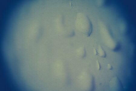 Water drops on window, shallow focus, vintage photo effect with paper texture.の写真素材