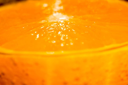 Fresh orange fruit slice in a glass of soda water, macro background.