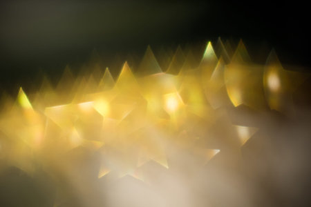 Festive background with defocused golden glitters, bokeh in a shape of a star.