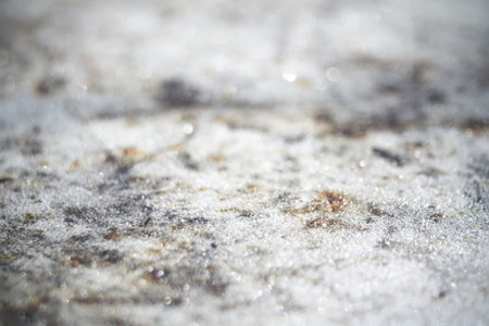 Natural frost pattern on grunge metal surface, blurred background with bokeh.