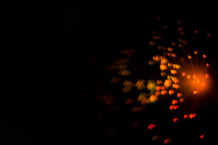 Defocused background with colorful bokeh in a shape of a heart.