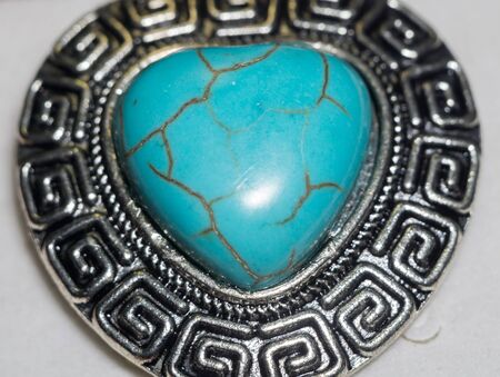 Big natural turquoise stone in a shape of a heart in metal frame.の写真素材