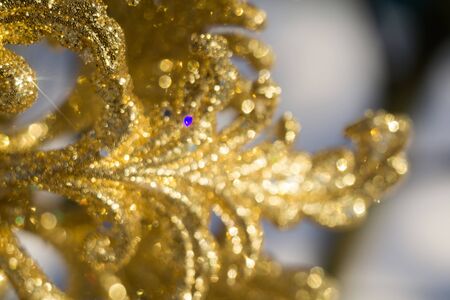 Ornamental golden snowflake glittering on fresh white snow.の写真素材