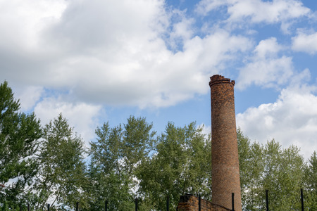 Old industry smoke stack over sunny blue sky.の写真素材