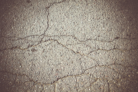 Old cracked, damaged asphalt road in countryside, vintage colors.の写真素材