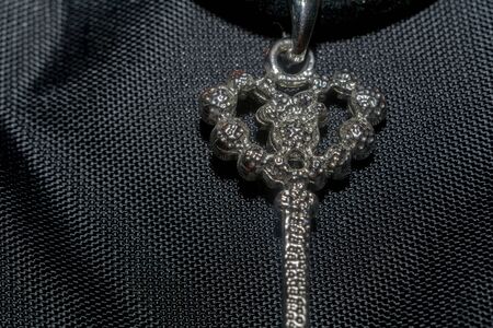 Silver pendant heart shaped key, made with pink crystal stones macro.の写真素材